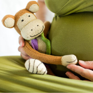 Kuschel-Affe umfasst mit seinen langen Armen den Babybauch