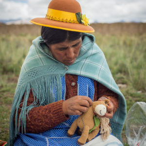 Peruanische Frau strickt Kuscheltier Pferd aus Bio Baumwolle