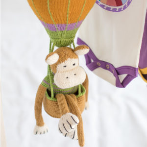 Kleiner handgestrickter Affe als Kinderzimmer Deko im Heißluftballon Mobile