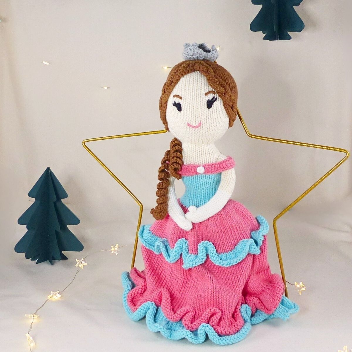 Handgestrickte Puppe Prinzessin aus Bio-Baumwolle im weihnachtlichen Setting mit Stern und Tannenbäumen