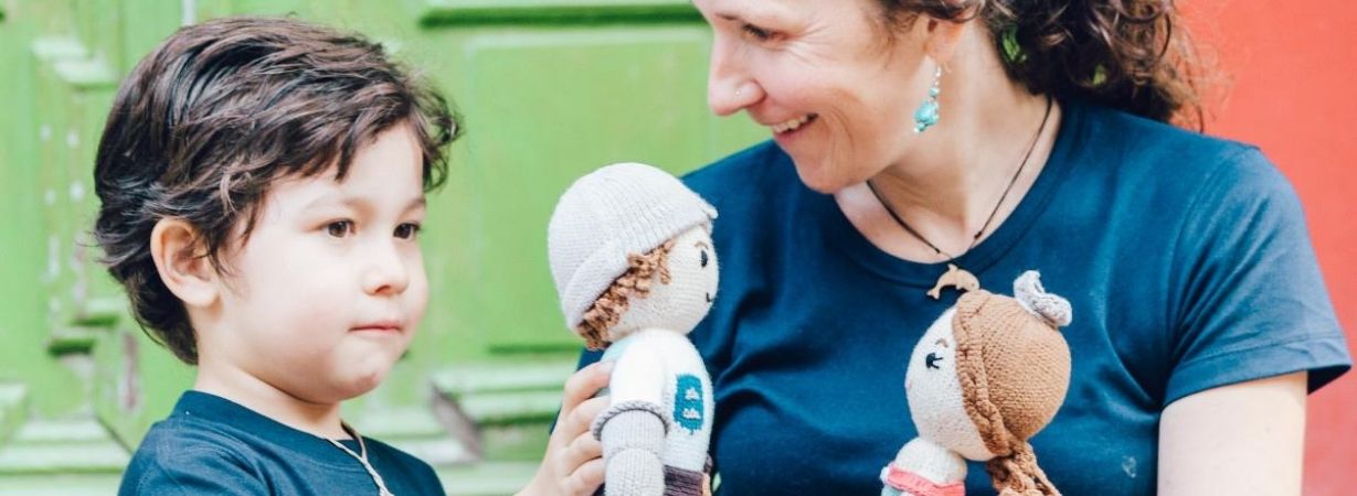 Mutter und Sohn spielen mit Puppen aus Bio Baumwolle