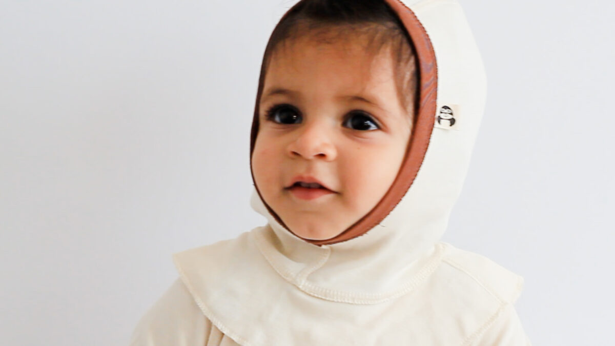 Dieses Bild zeigt ein Baby, das eine Schlupfmütze bei Neurodermitis trägt. Die Mütze besteht aus 100% GOTS-zertifizierter Pima Schlupfmütze bei Neurodermitis mit integrierten Außennähten für optimalen Hautschutz.