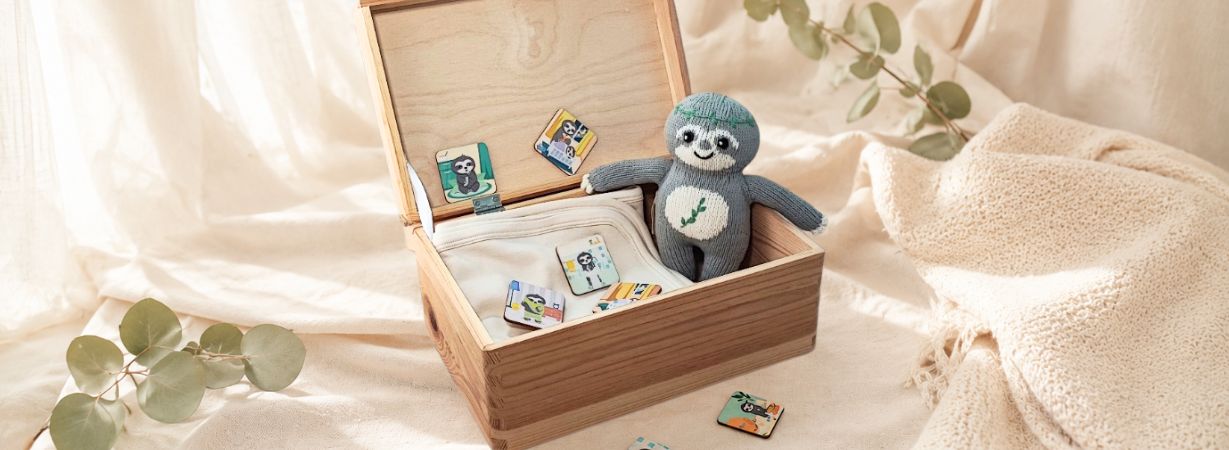Einschlafhilfe für Kinder: handgestricktes Faultier in Holzbox mit liebevoll gestalteten Routinekarten für ein entspanntes Abendritual.