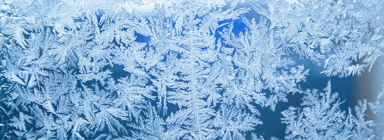 Eiskristalle basteln aus Salz und Wasserfarbe auf schwarzem Papier.