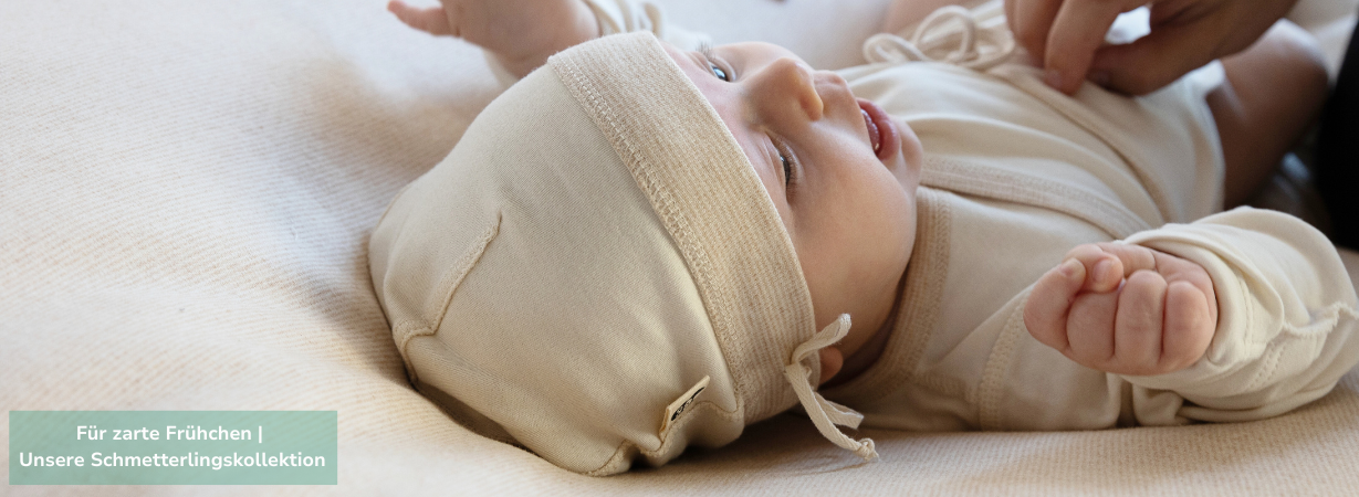 Geschenke für Frühchen: Frühgeborenes Baby in sanfter Bio-Kleidung aus der Schmetterlingskollektion mit Mütze und Wickelbody