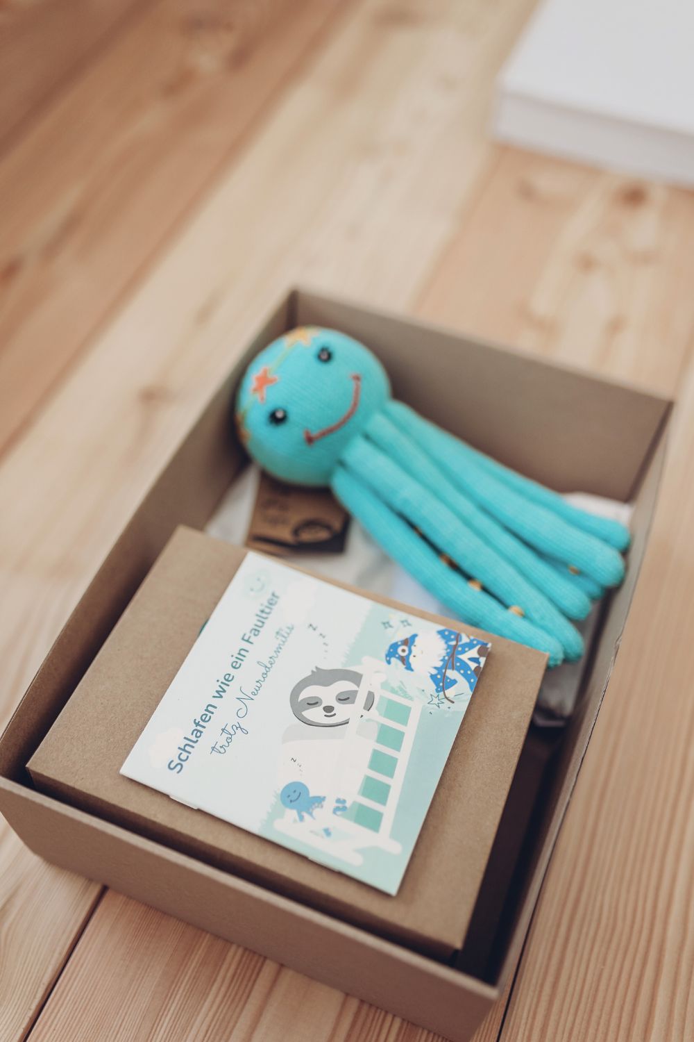 Liebevoll verpackte Geschenkbox mit Bio-Kuscheltier-Qualle – ein handgemachtes Geschenk, das Großeltern hilft, Nähe und Kontakt zum Enkel zu schenken.