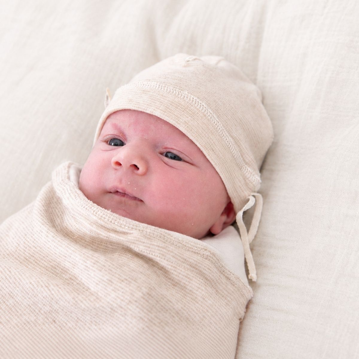 Frühchen Mütze aus Bio-Baumwolle an einem Neugeborenen – weiche Babymütze mit Zugband für empfindliche Babyhaut