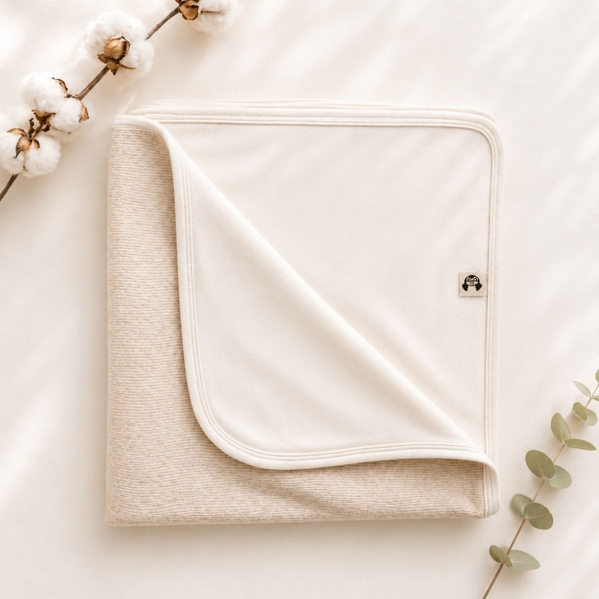 Bio Babydecke aus Pima Baumwolle in Naturbeige auf weichem Stoffhintergrund
