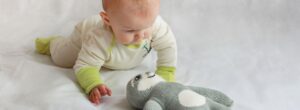 Baby spielt in hautfreundlicher Neurodermitis Kleidung mit integriertem Kratzschutz – atmungsaktiv, weich und schützend