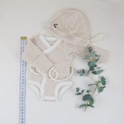 Frühchen Wickelbody in Größe 42, geringelt in Beige-Naturtönen, mit Mütze und Maßband als Größenvergleich, liebevoll arrangiert mit Eukalyptuszweig auf hellem Hintergrund