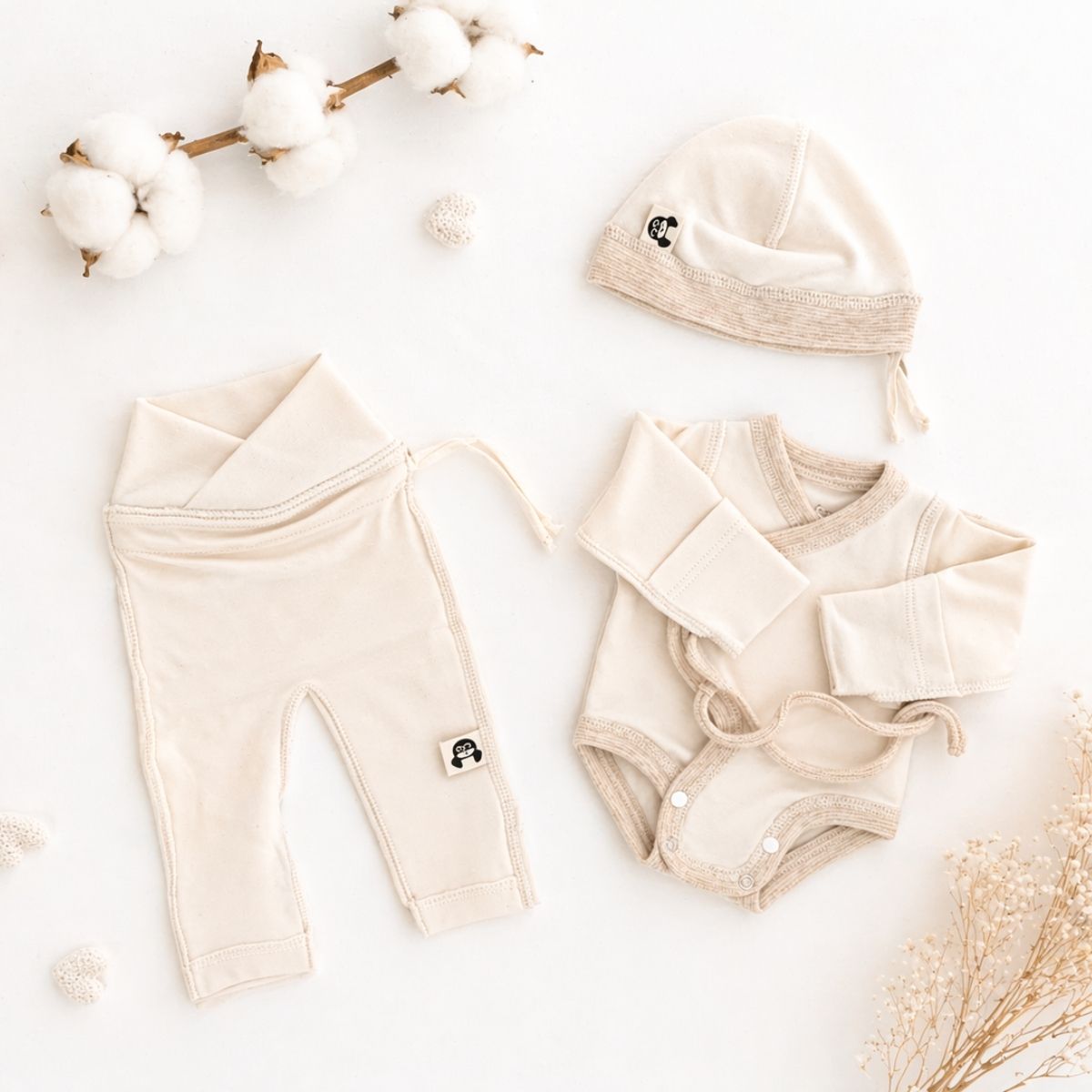 Minimalistisches Baby Erstausstattung Set aus Bio Baumwolle für Neugeborene mit Body, Hose und Mütze in sanften Naturtönen