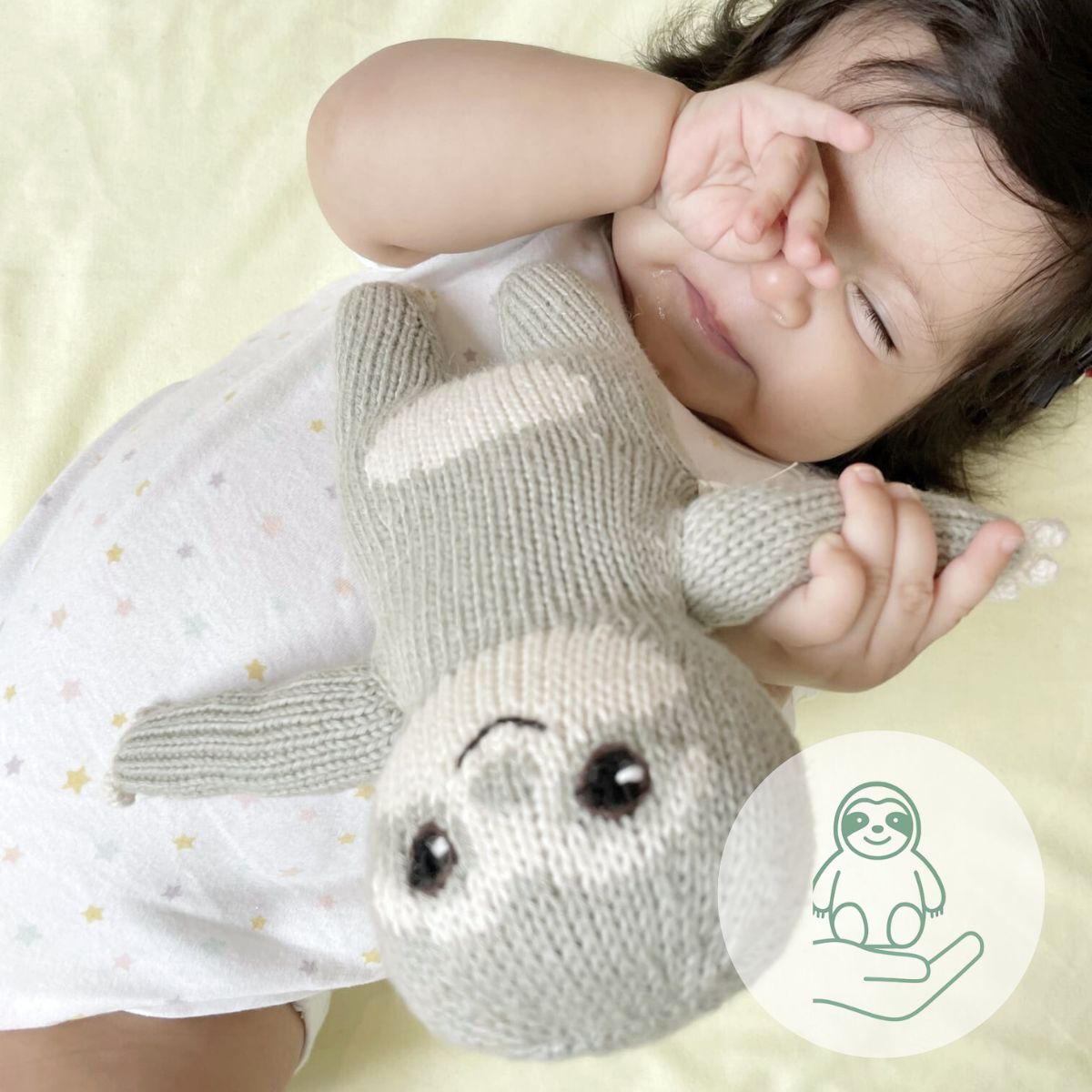 Baby kuschelt mit einem gestrickten Faultier – formechtes Kuscheltier aus Bio-Baumwolle