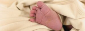 Ein Babyfuß liegt eingehüllt in einer weichen Decke aus GOTS-zertifizierter Bio-Baumwolle. Die Decke zeigt, wie man ein Baby richtig zudecken kann – sanft, sicher und ohne zu beschweren.
