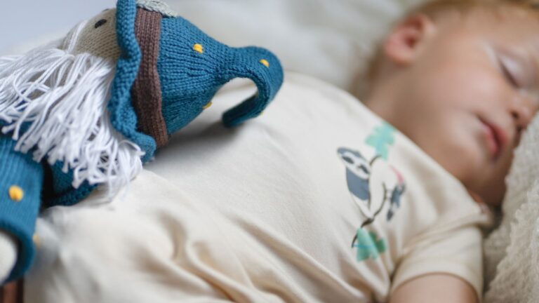 Sleeping baby wearing soft eczema-friendly clothing made from skin-friendly materials