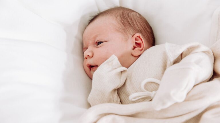 Premature baby resting peacefully in soft, gentle clothing designed for fragile skin