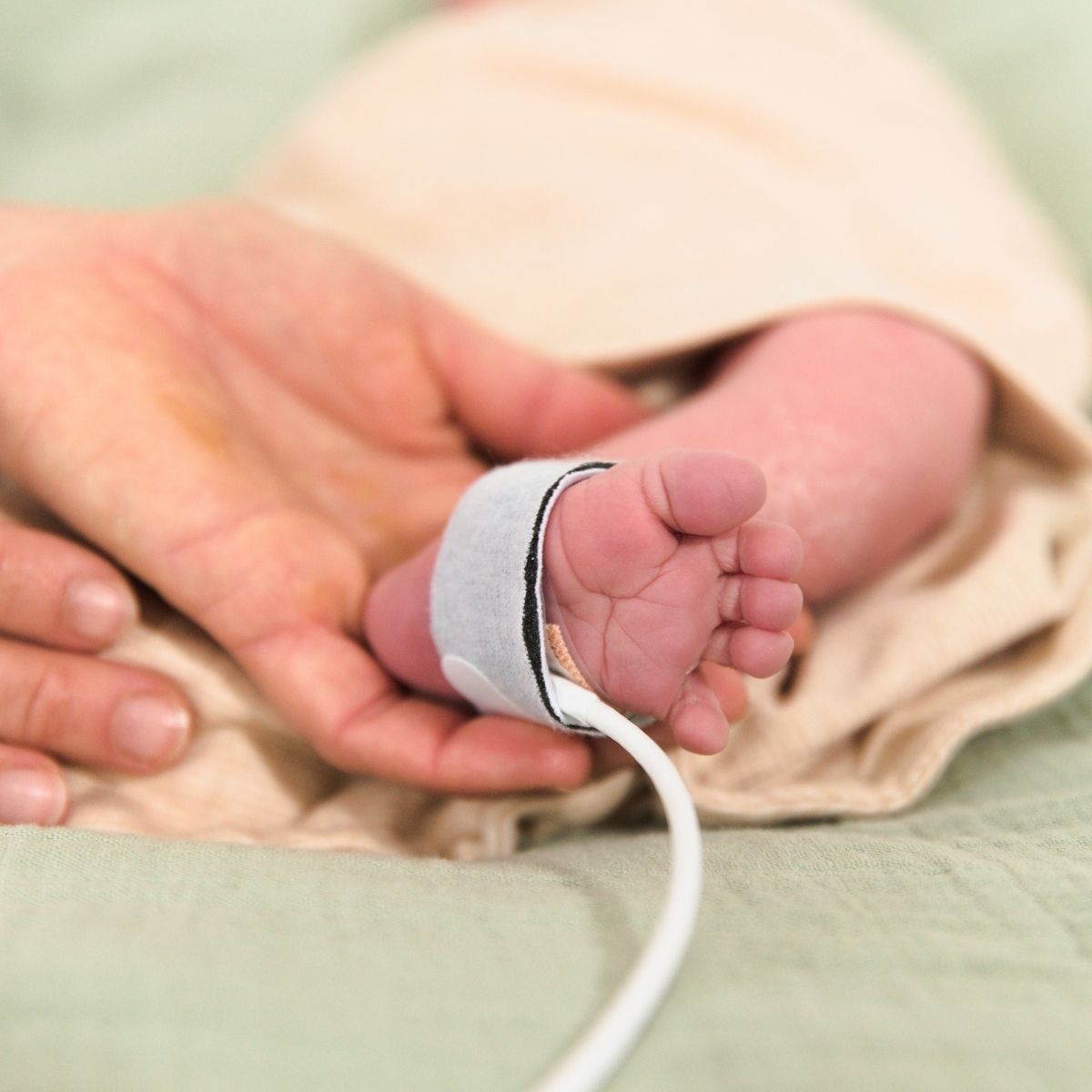 Detailaufnahme von Frühchenkleidung mit freiem Zugang für medizinisches Monitoring am Fuß