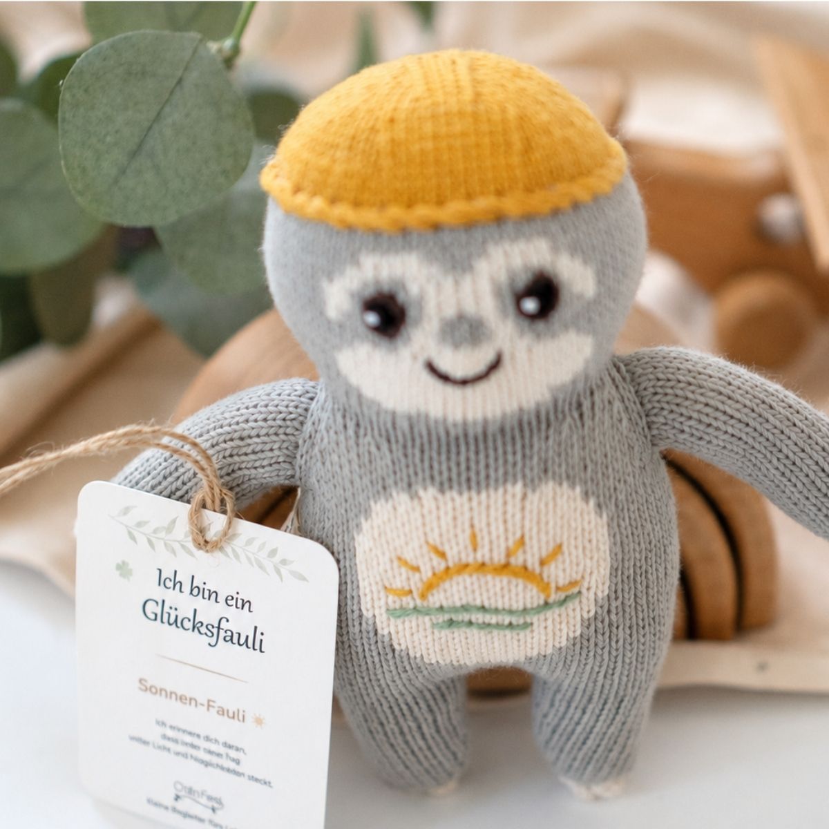 Nahaufnahme vom Baby Faultier Sonnen-Fauli aus Bio-Baumwolle mit gesticktem Sonnenmotiv und Glücksbotschaft