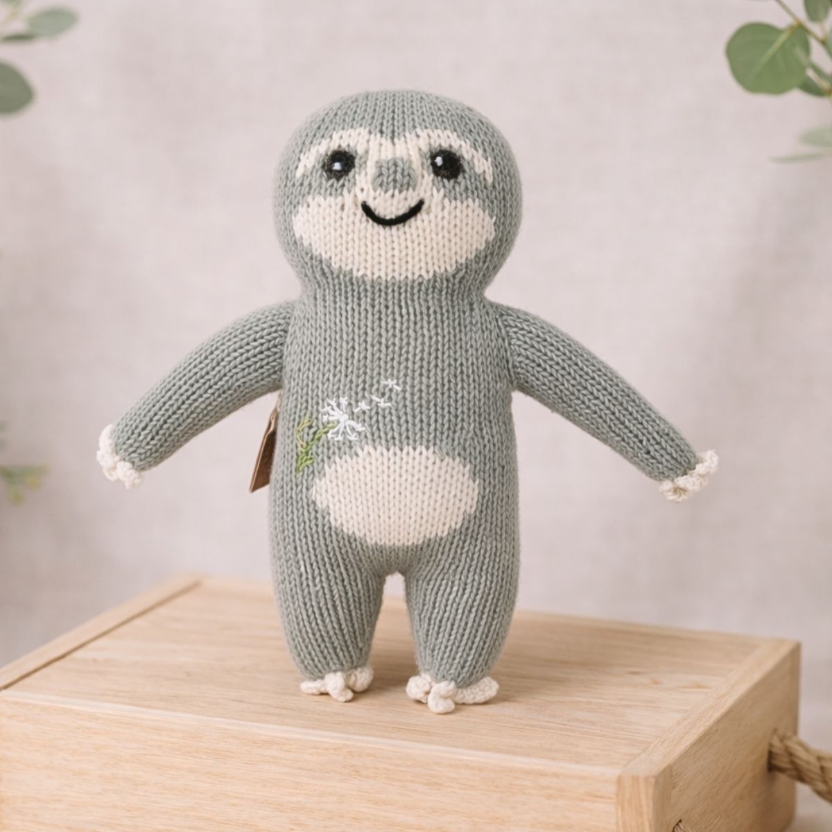 Bio Faultier Stofftier Pusteblumen-Fauli handgestrickt auf Holzbox