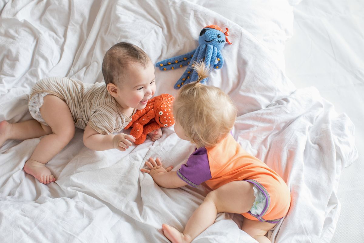 Kinder spielen mit Kuscheltieren – Geschwistergeschenk zur Geburt