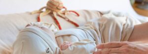 Kleidung für Frühchen im Krankenhaus: Frühchen mit weicher Mütze und Kleidung beim Hautkontakt
