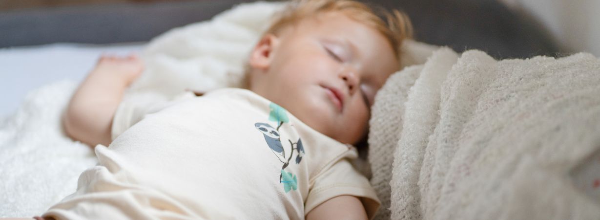 Baby schläft ruhig in besonders weicher Neurodermitis Kleidung aus Pima Baumwolle als Alternative zu Silberkleidung