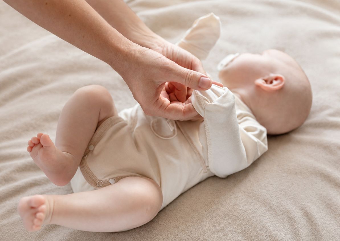 Mutter prüft nachts sanft den Nacken ihres Babys zur Kontrolle der Körpertemperatur bei Sommerhitze