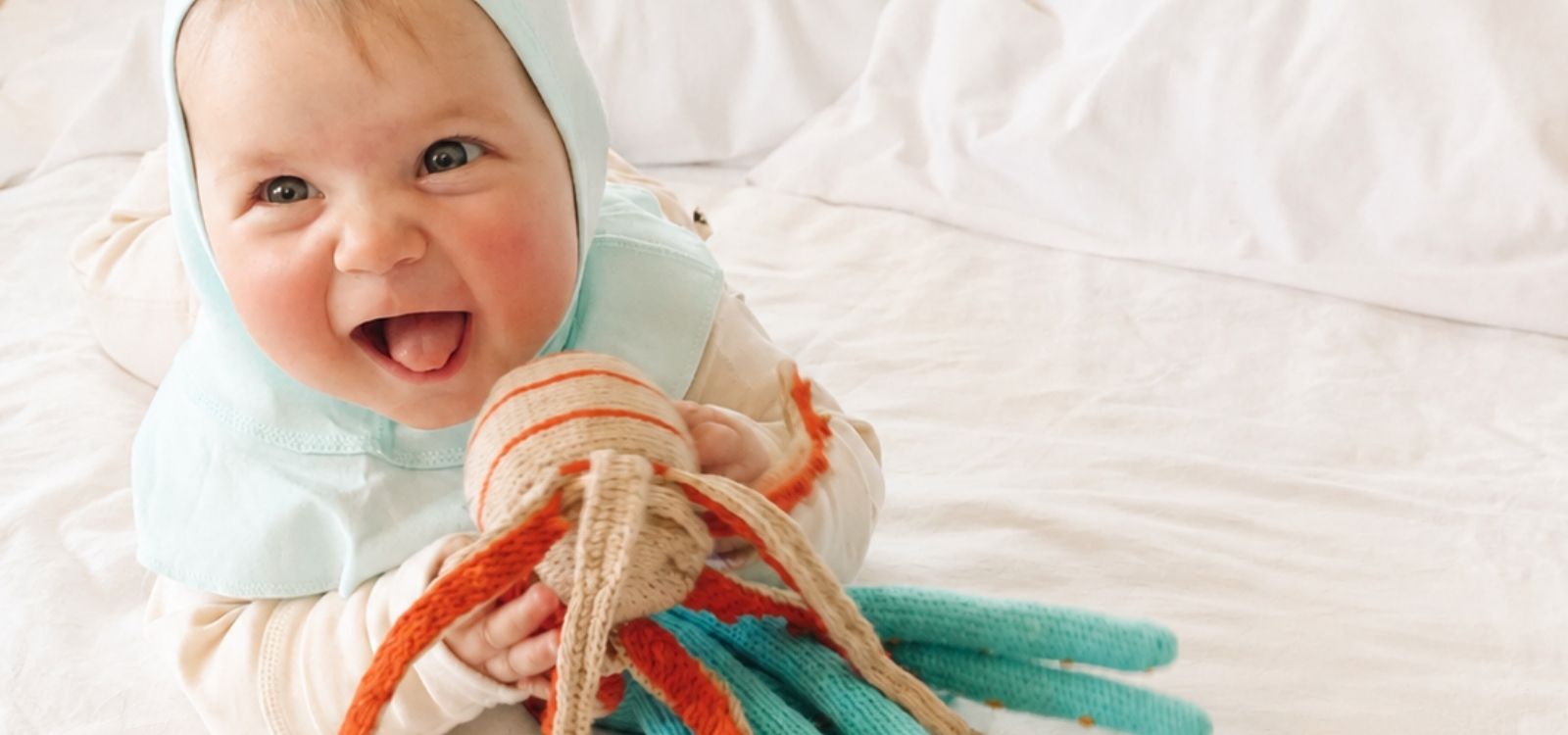 Baby mit einem Kuscheloktopus in Kleidung von Chill n Feel