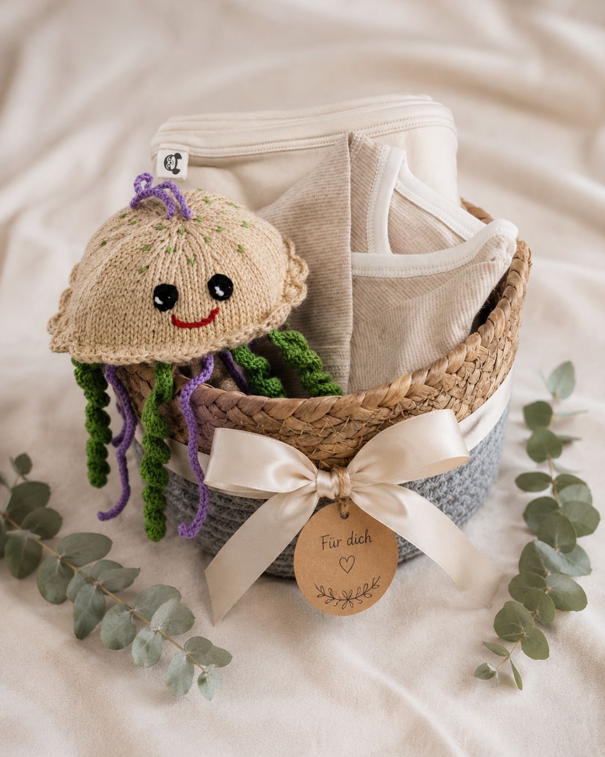 Babygeschenk verpacken im Geschenkkorb mit Babydecke, Babybody und handgestrickter Qualle