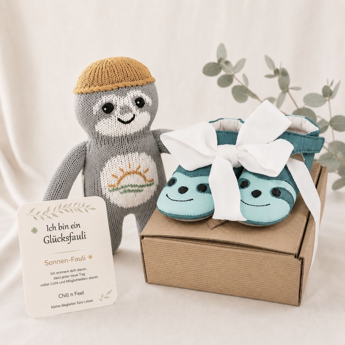Besonderes Geschenk zur Geburt mit Sonnen-Fauli Glücksbringer und Babyschuhen für die ersten Schritte ins Leben