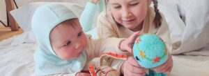 Geschwister Kuscheltiere für Baby und Geschwisterkind beim gemeinsamen Spielen und Entdecken