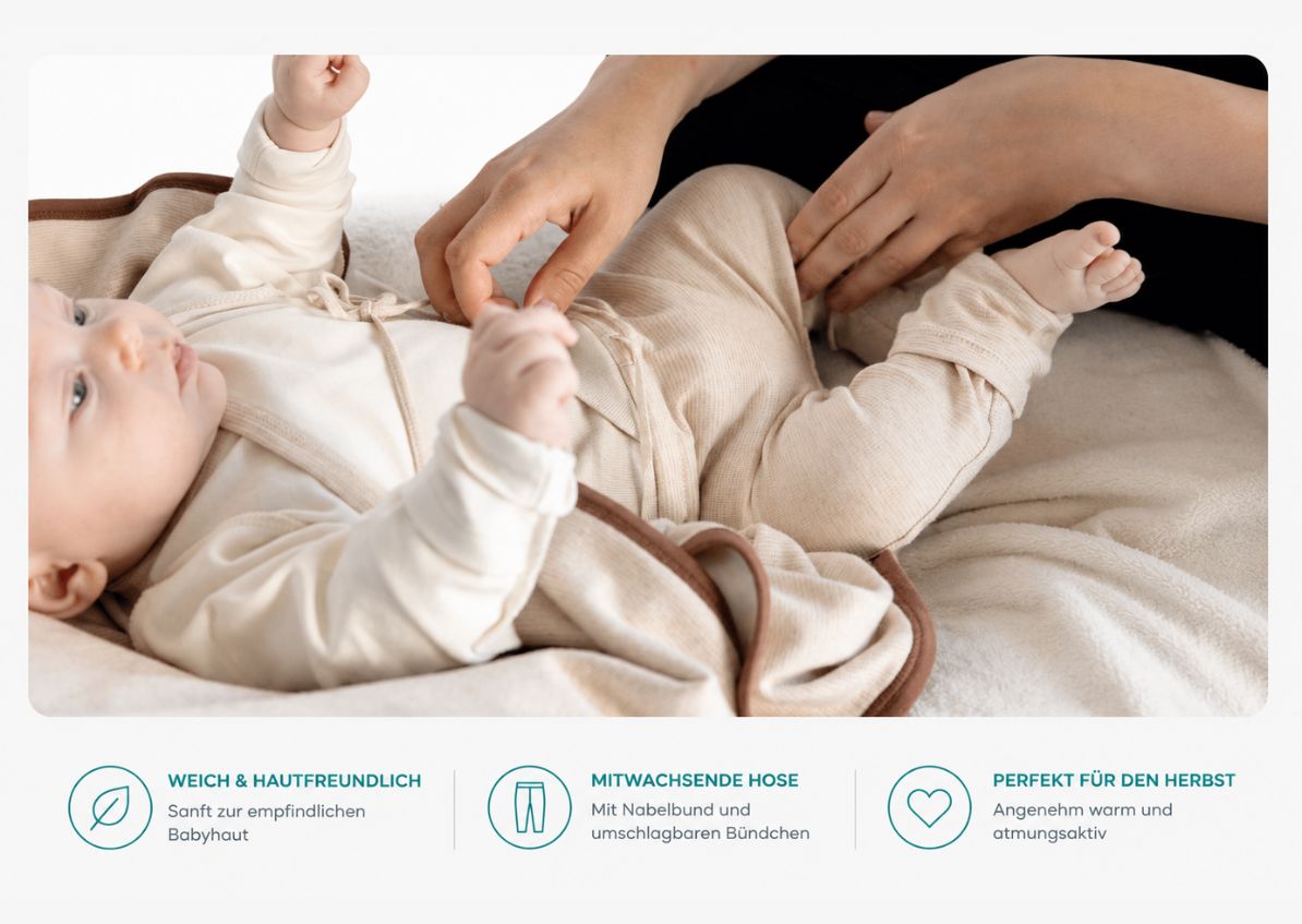 September Baby in Wickelbody und mitwachsender Hose aus Pima Baumwolle beim Anziehen im Herbst