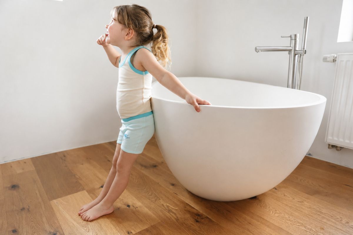 Ist Salzwasser gut für die Haut? Ein Kind steht vor einer Badewanne und bereitet sich auf ein Salzbad vor