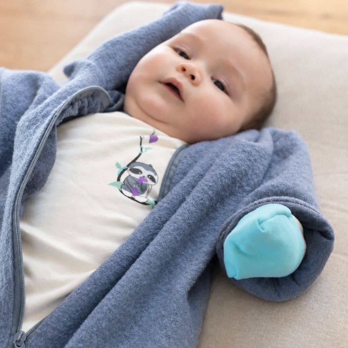 Baby mit Neurodermitis trägt weiche Pima-Kleidung unter einem warmen Fleeceoverall